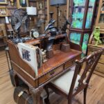 Queen Anne Revival writing desk and matching chair with cabriole legs, carved shell detailing, and upholstered seat — vintage hardwood furniture set.