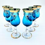 Set of six blue Romanov-style goblets with gold rims and jeweled enamel detailing.
