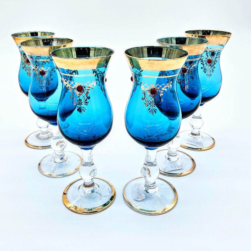 Set of six blue Romanov-style goblets with gold rims and jeweled enamel detailing.