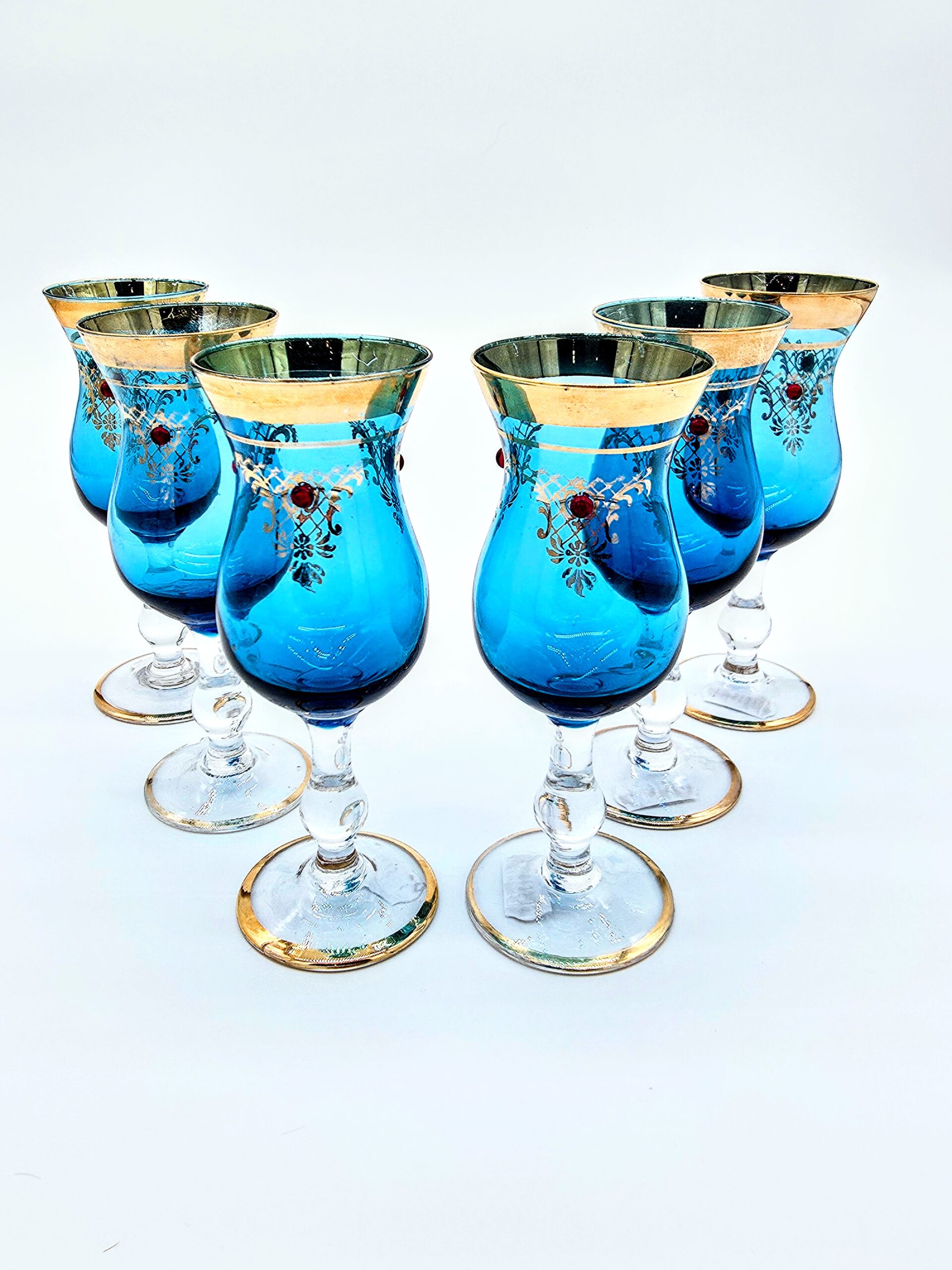 Set of six blue Romanov-style goblets with gold rims and jeweled enamel detailing.