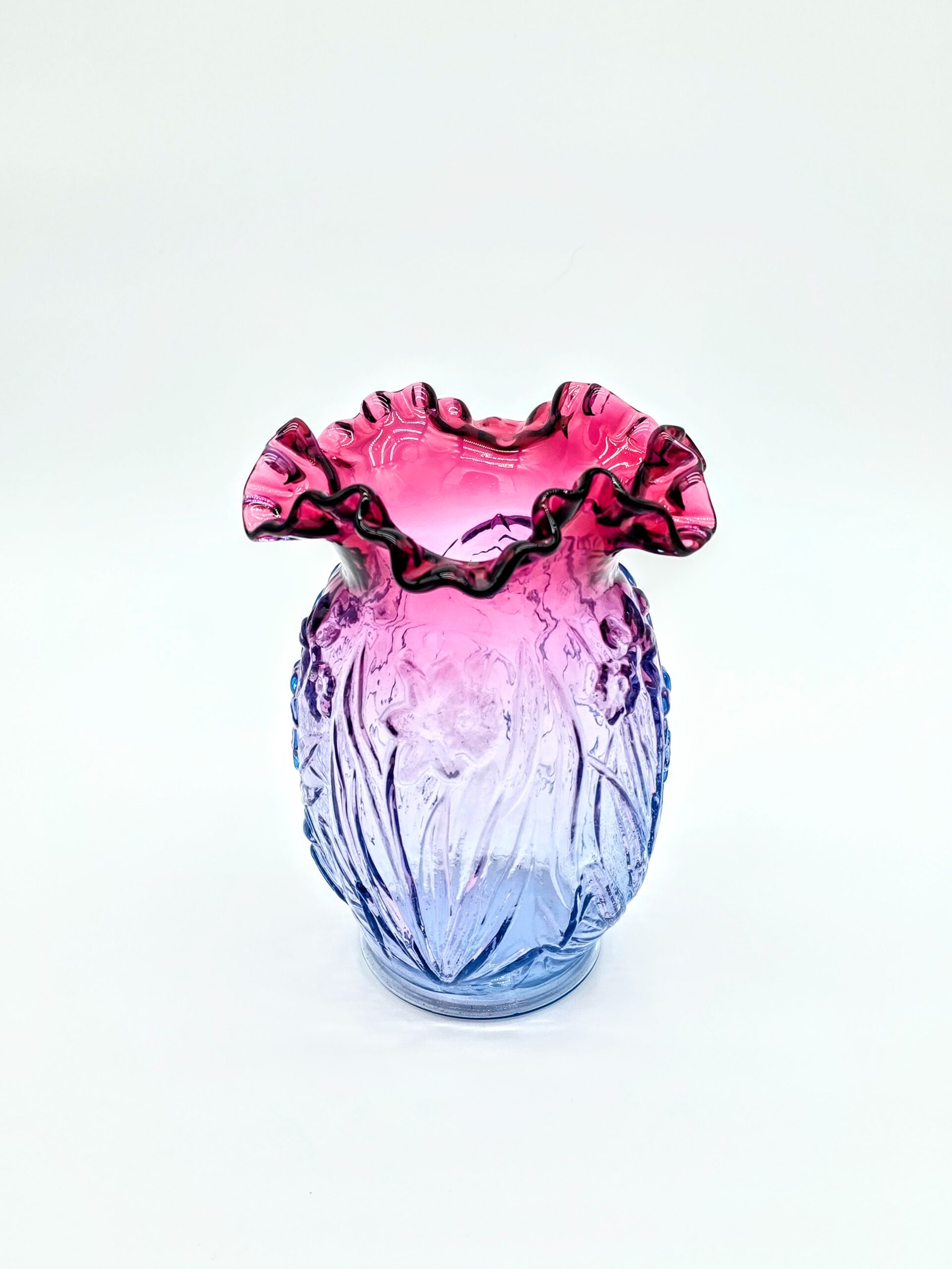 Fenton blue to pink ombré ruffled art glass vase with floral embossed pattern and fluted rim.