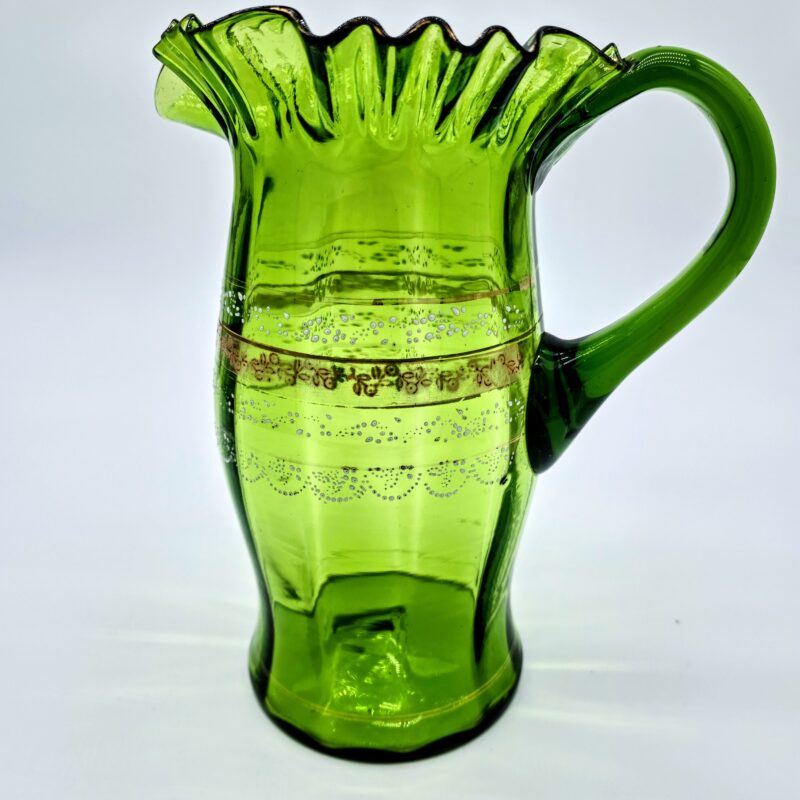 Vintage green glass pitcher with ruffled rim and gold painted band detailing.