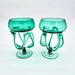 Pair of handblown green art glasses with sculptural stems inspired by jellyfish design.