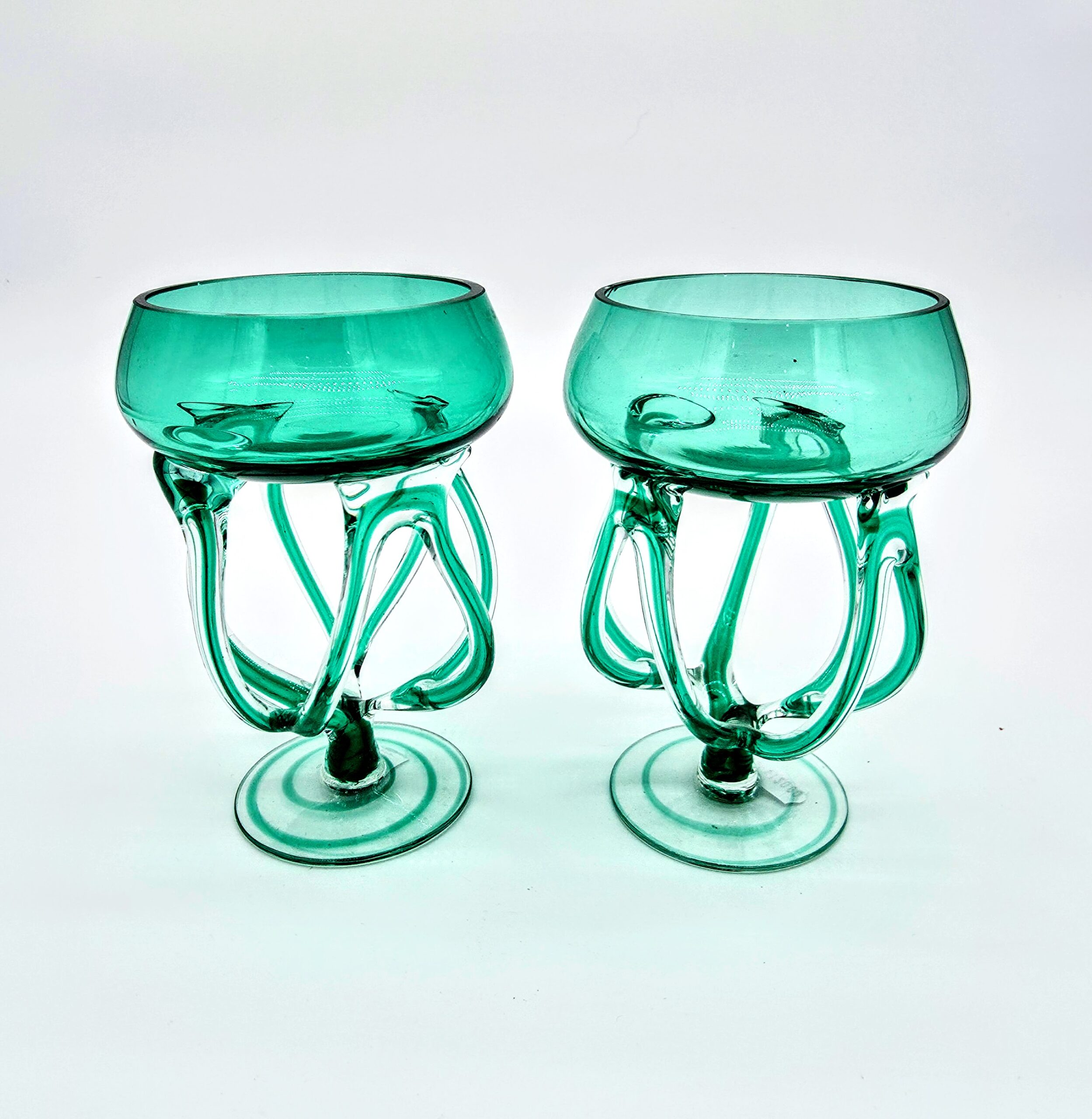 Pair of handblown green art glasses with sculptural stems inspired by jellyfish design.