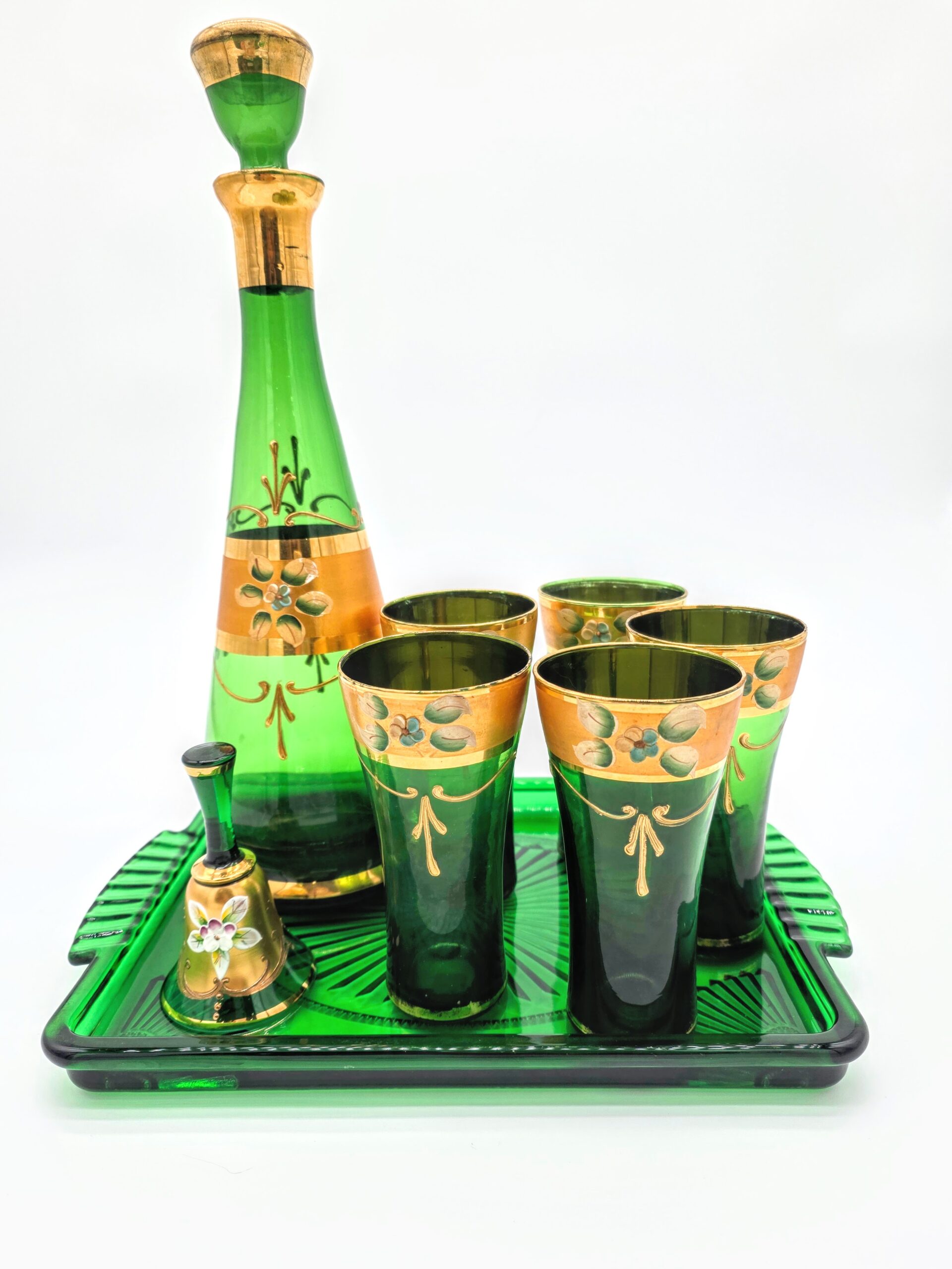 Green and gold Oriental-style glass decanter set with tray, glasses, and bell featuring floral enamel design.