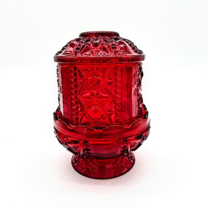 Vintage red pressed glass fairy light with starburst pattern and pedestal base.