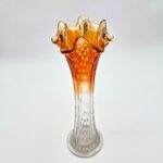 Orange fluted glass vase with hobnail texture and ruffled rim transitioning from clear to amber.