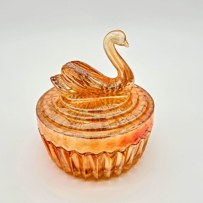 Vintage orange pressed glass candy dish with swan-shaped lid and ribbed base.