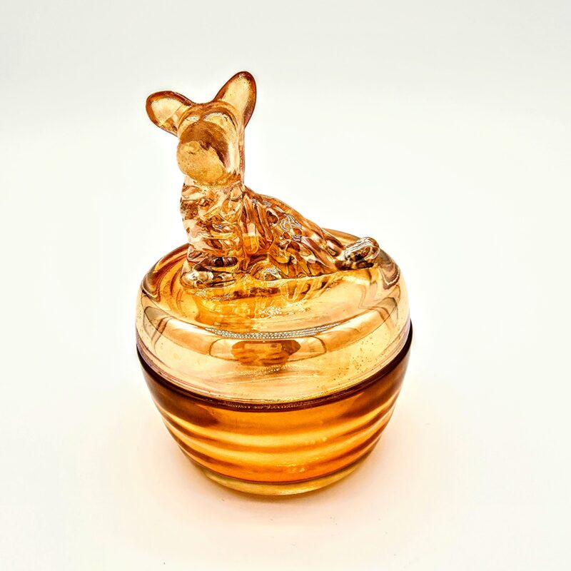 Vintage orange pressed glass candy dish with dog-shaped lid and smooth amber finish.