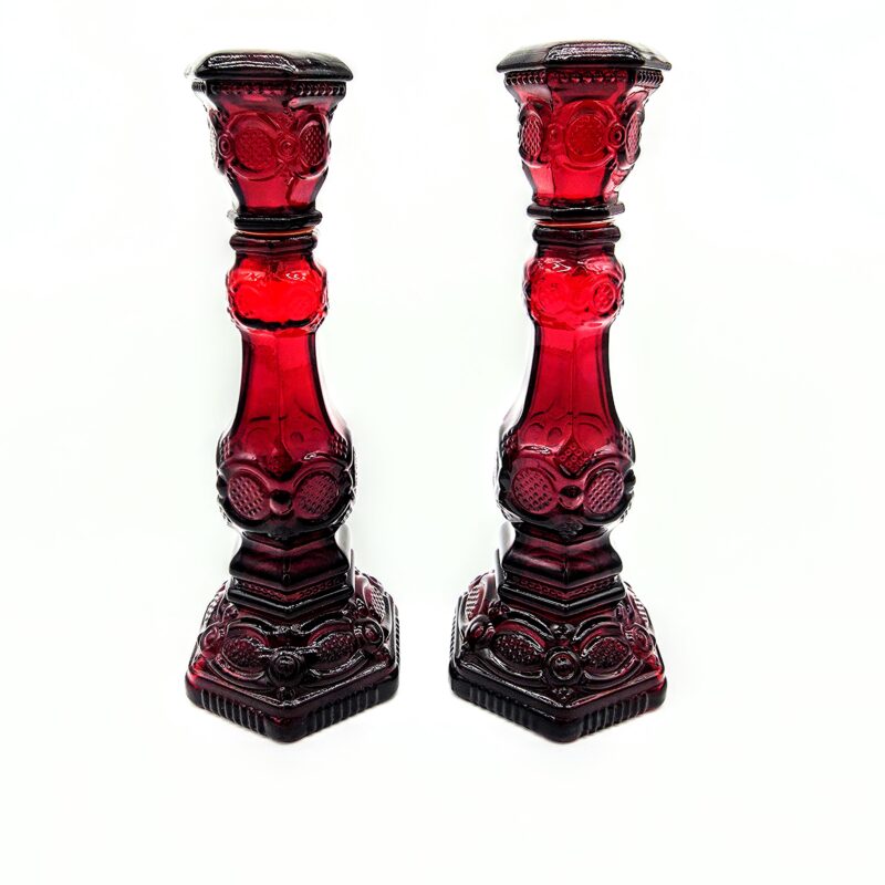 Pair of vintage red Waterford glass candlesticks with cut crystal design and faceted hexagonal bases.