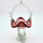 Hand-blown red glass basket with clear twisted handle and ruffled rim, vintage art glass collectible.