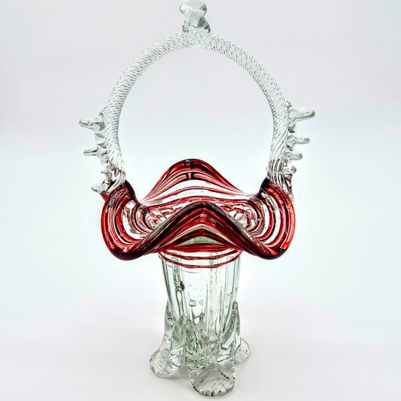 Hand-blown red glass basket with clear twisted handle and ruffled rim, vintage art glass collectible.
