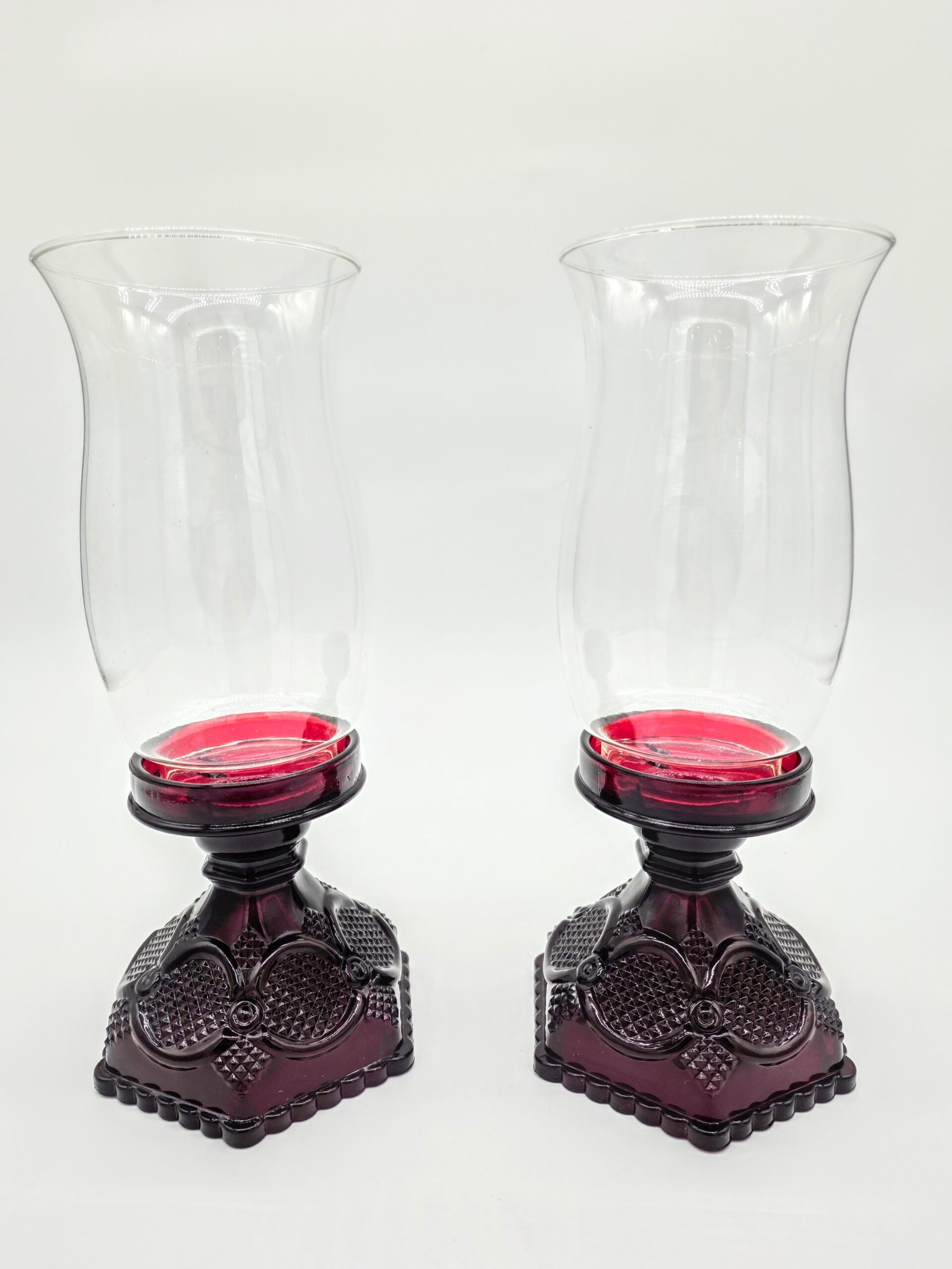 Pair of red Waterford glass candle holders with clear fluted hurricane tops, vintage crystal lighting décor.