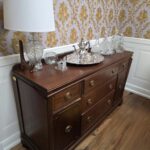 Vintage hardwood sideboard with brass-style hardware, paneled doors, and drawers — classic solid wood storage furniture.