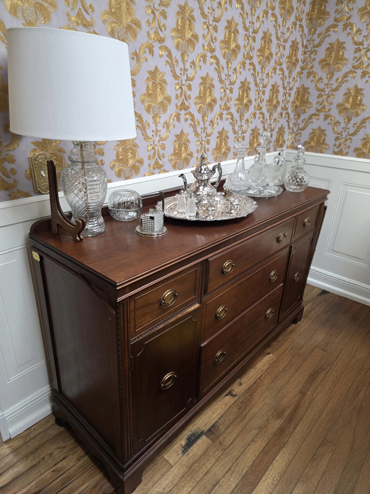 Vintage hardwood sideboard with brass-style hardware, paneled doors, and drawers — classic solid wood storage furniture.