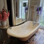 Victorian slipper clawfoot bathtub with white porcelain finish and ornate cast iron legs — vintage luxury bathroom fixture.